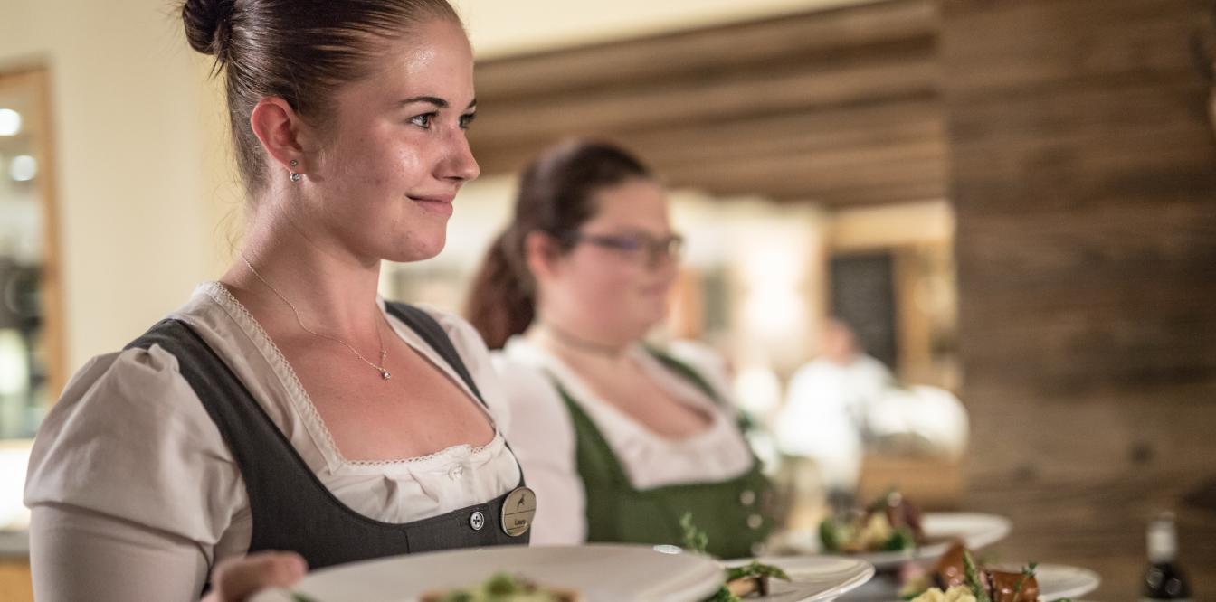 Kellnerinnen im Dirndl servieren das Abendessen im Restaurant des Seehotl Jägerwirt. Abendessen beim Jägerwirt