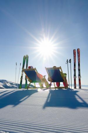 Pisten-Liegestuhl Zwei Skifahrer machen Pause und nutzen die Liegestühle die an den Pisten aufgestellt wurden. Ein Service der Region Turracher Höhe.