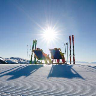 Pisten-Liegestuhl Zwei Skifahrer machen Pause und nutzen die Liegestühle die an den Pisten aufgestellt wurden. Ein Service der Region Turracher Höhe.