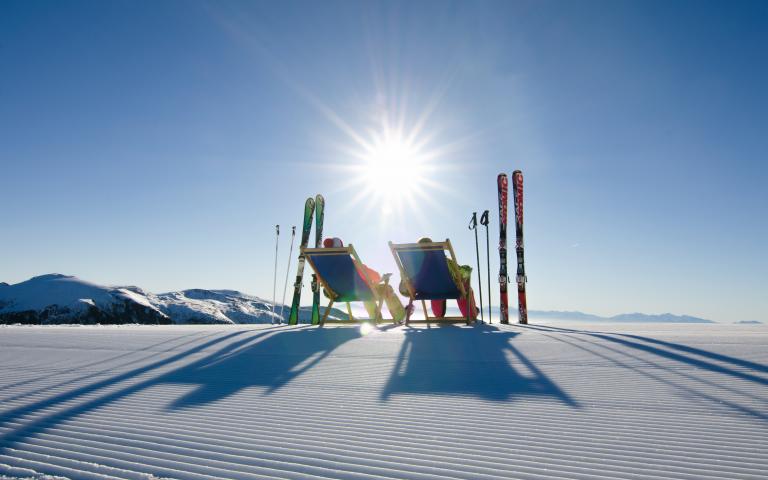 Pisten-Liegestuhl Zwei Skifahrer machen Pause und nutzen die Liegestühle die an den Pisten aufgestellt wurden. Ein Service der Region Turracher Höhe.